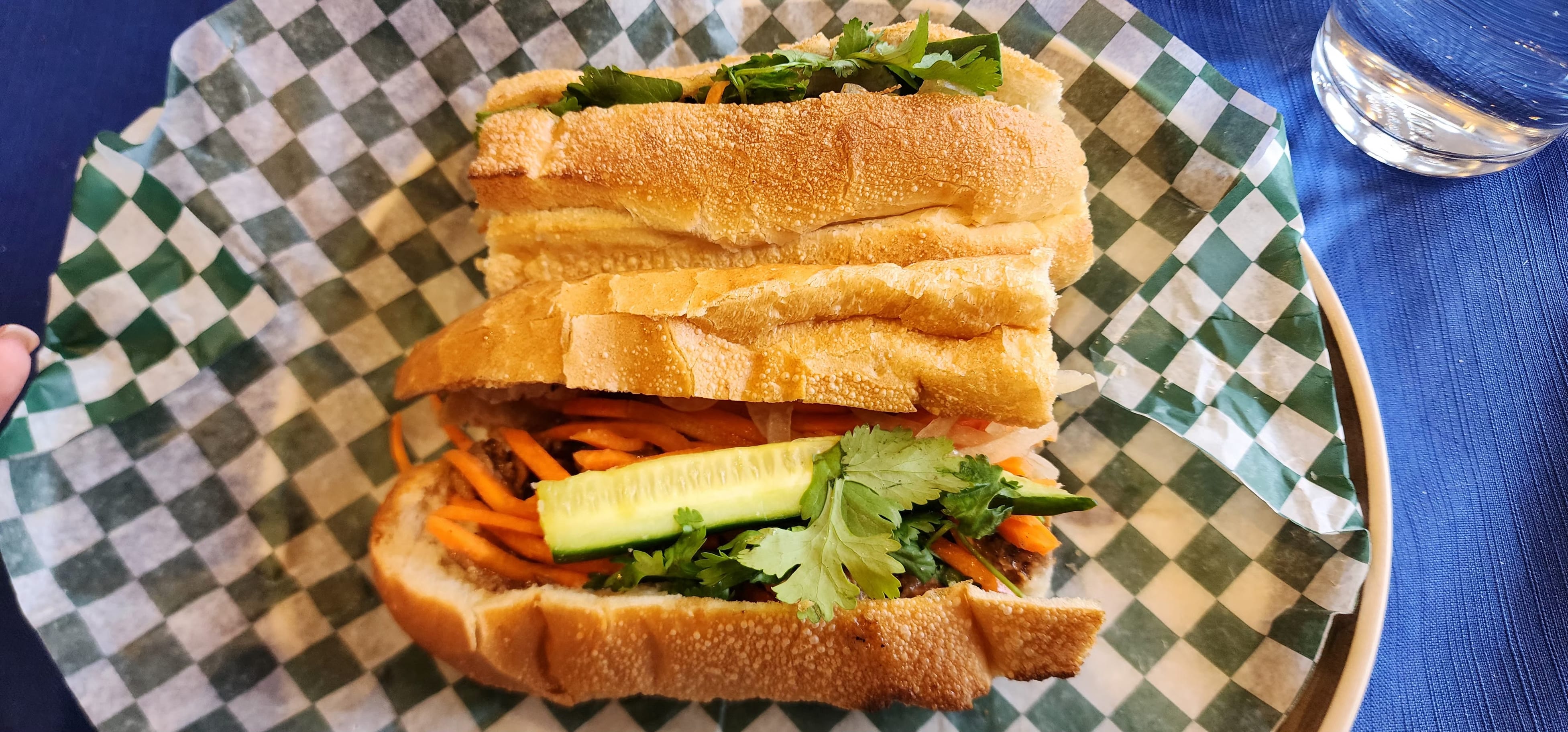 A Vietnamese sub with carrot, cucumber and cilantro on checkered paper at Golden Bell